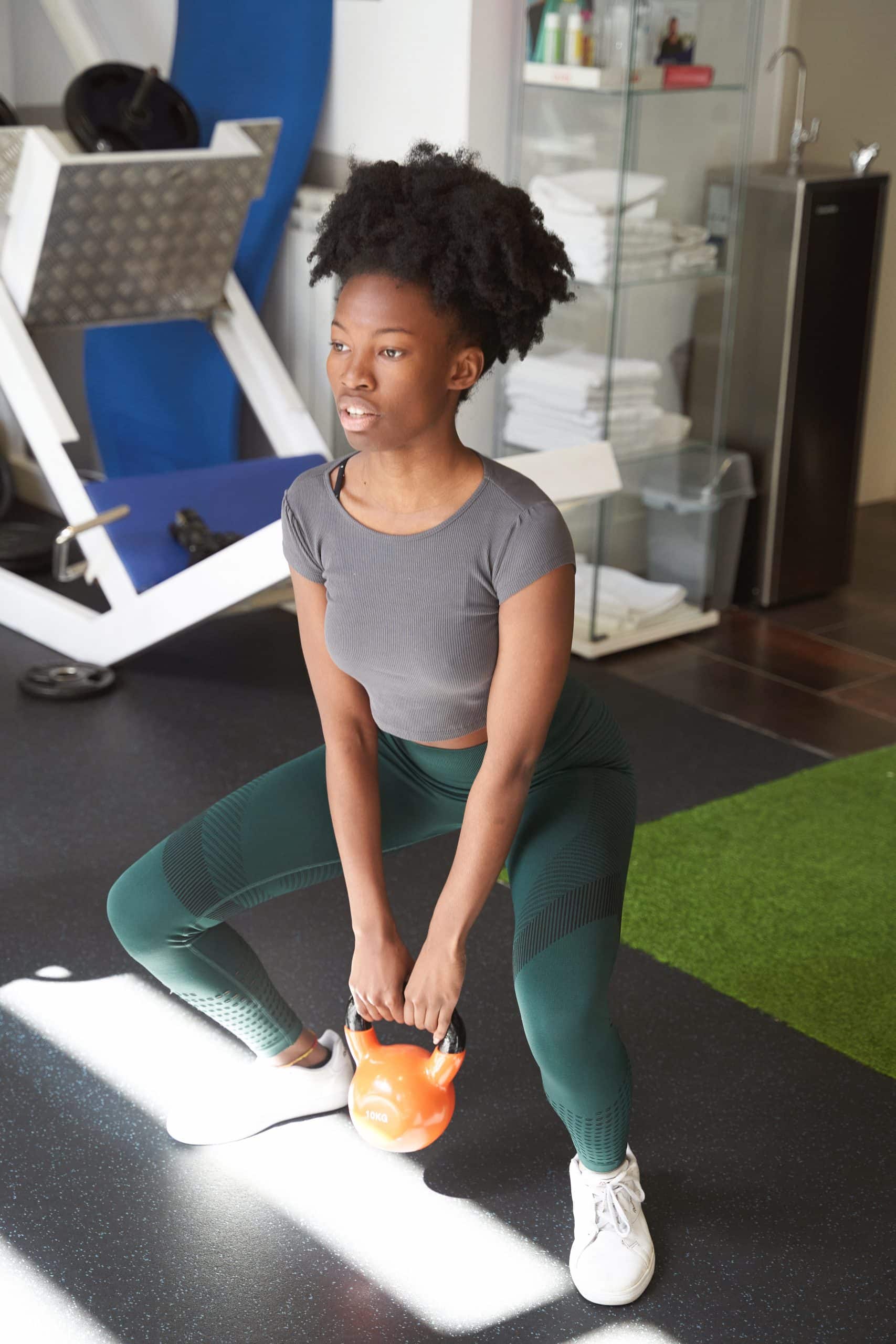 african fitness woman training with a barbell in the gym